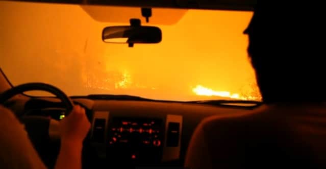 vue d'une forêt russe en flammes à travers un pare-brise de voiture