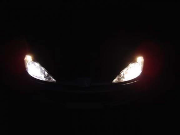 les phares d'une peugeot 206 dans la nuit
