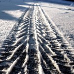 photographie d'une trace de pneu dans la neige
