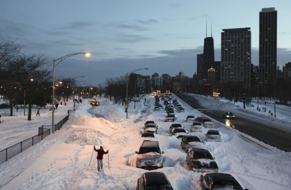 un skieur en ville entre les vehicules