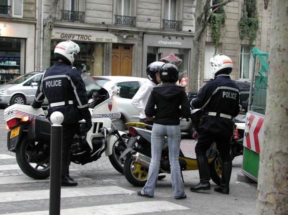 deux policiers contrôlent deux jeunes à scooter