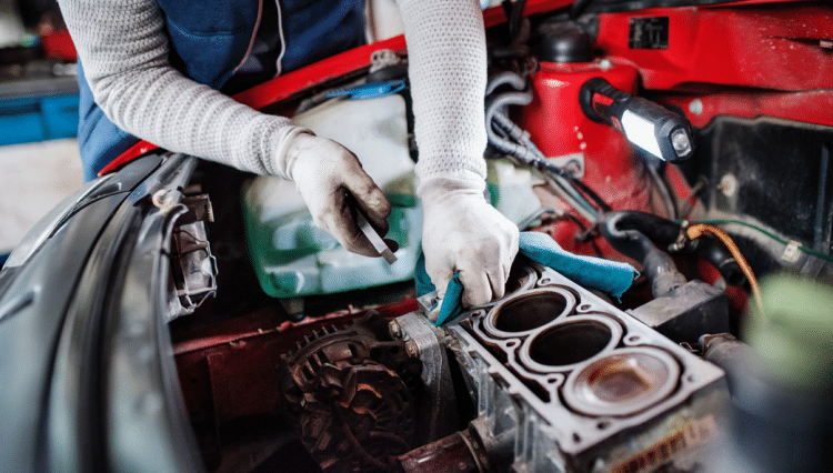 Un garagiste qui entretien le moteur d'une voiture