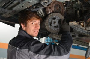 Un garagiste entrain de changer un embrayage sur une voiture