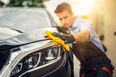 Un homme en train de protéger la peinture de sa voiture