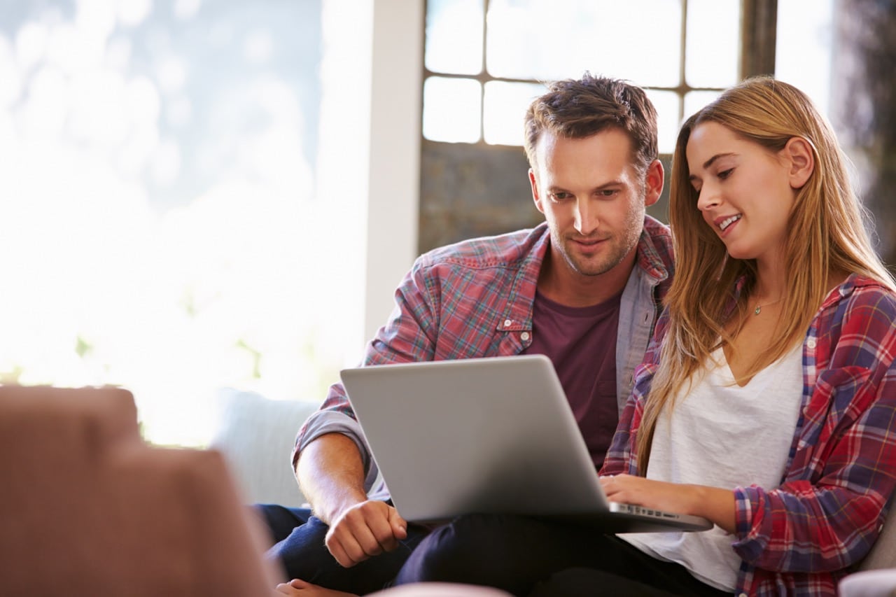 Une couple en train de modifier leur carte grise sur internet car ils viennent de déménager