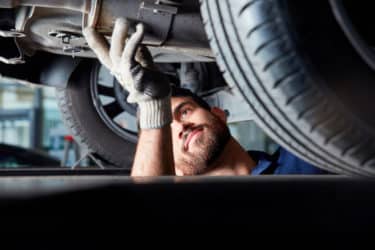 Un mécanicien en train d'installer des pièces d'occasion sur une voiture