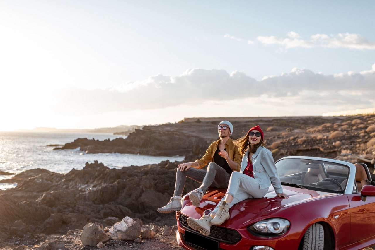 Un jeune couple en voyage à l'étranger avec leur voiture