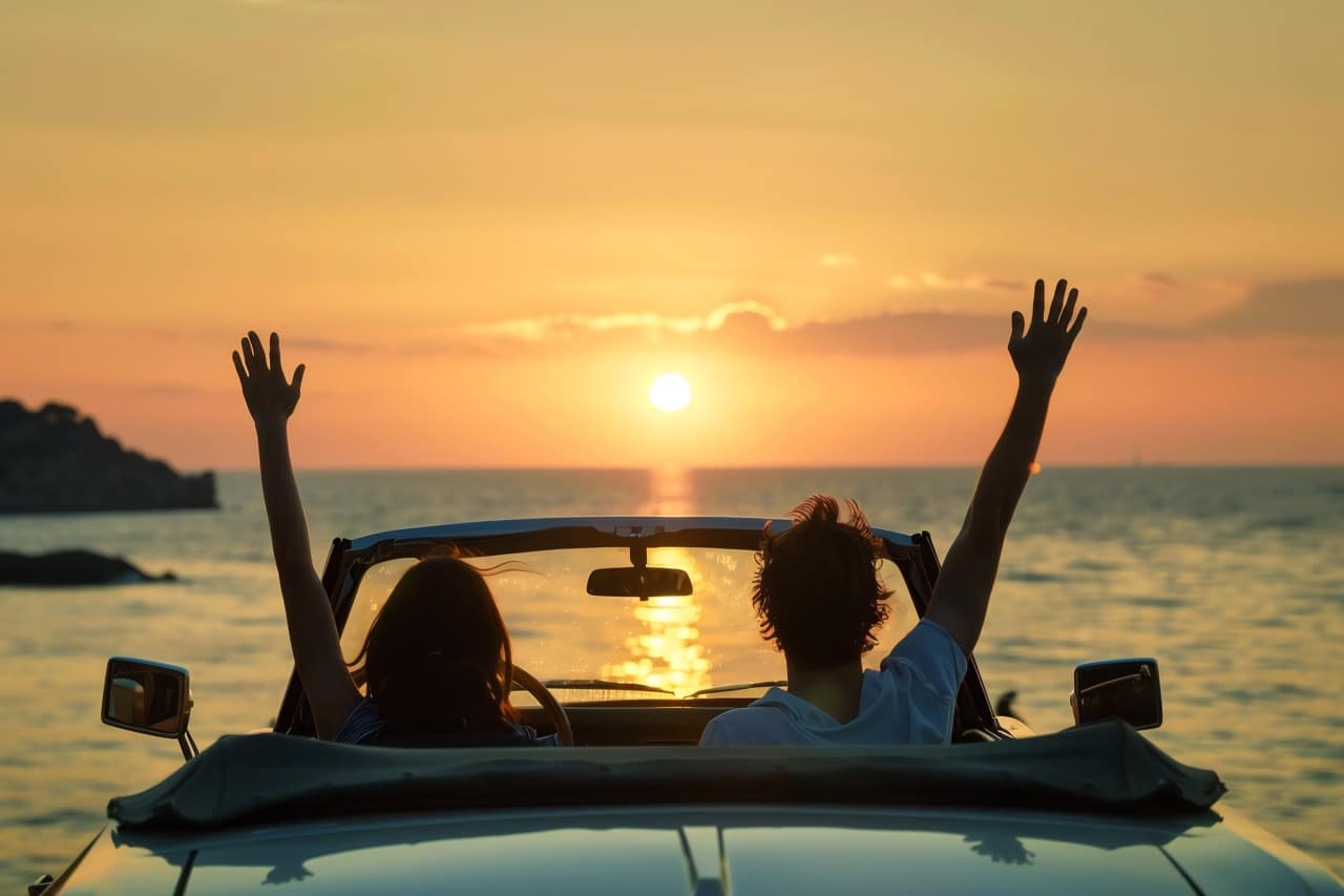 Une couple dans leur cabriolet de location en vacance sur la cote d'azur