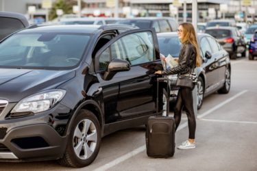 Une femme loue une voiture à l'aéroport ou elle a atterri pour passer ses vacances