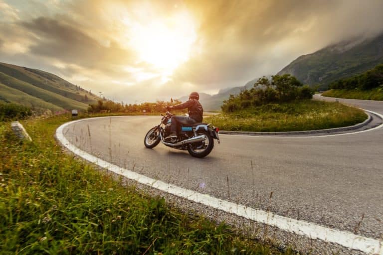 Un motard sur une route de montagne au guidon de sa moto