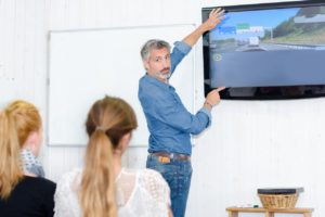 Un groupe de jeunes en train d'essayer de passer le Code de la route dans une auto-école