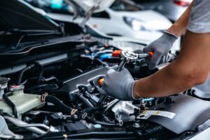 Mécanicien réparant un moteur avec des pièces auto revalorisées, illustrant l’économie circulaire dans le secteur automobile