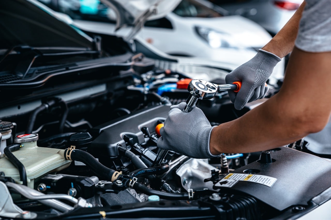 Mécanicien réparant un moteur avec des pièces auto revalorisées, illustrant l’économie circulaire dans le secteur automobile