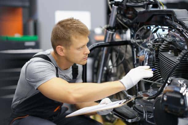 Un homme expertise une moto pour déterminer sa valeur pour l'assurance en vue de l'indemniser