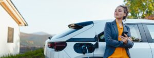 Une femme attend que sa voiture hybride se recharge