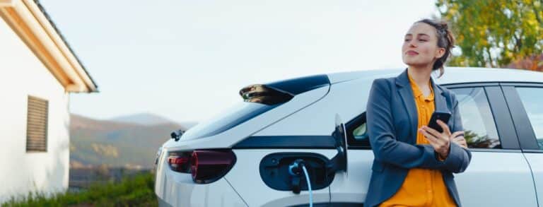 Une femme attend que sa voiture hybride se recharge